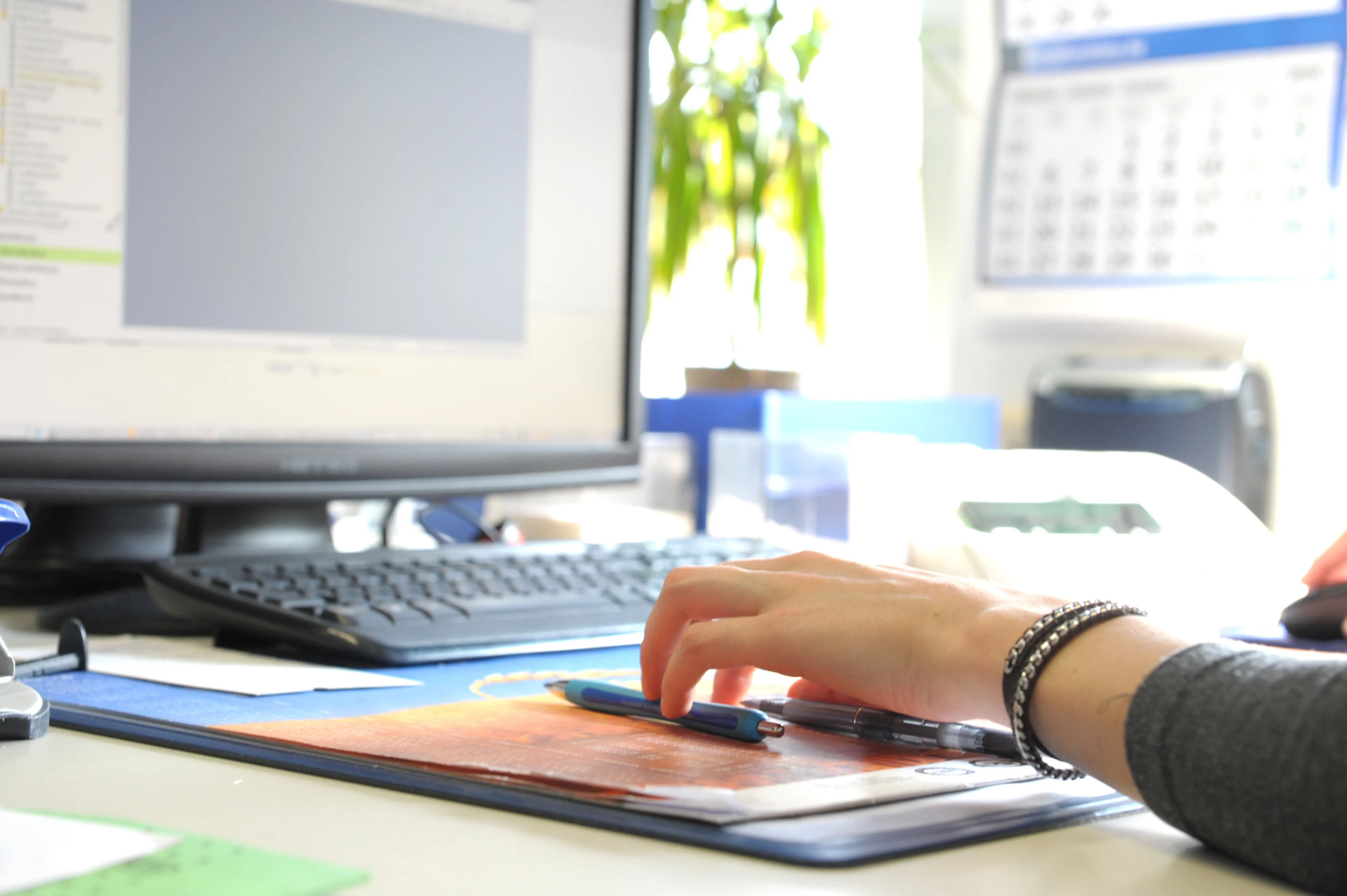 Person arbeitet am Schreibtisch am Computer