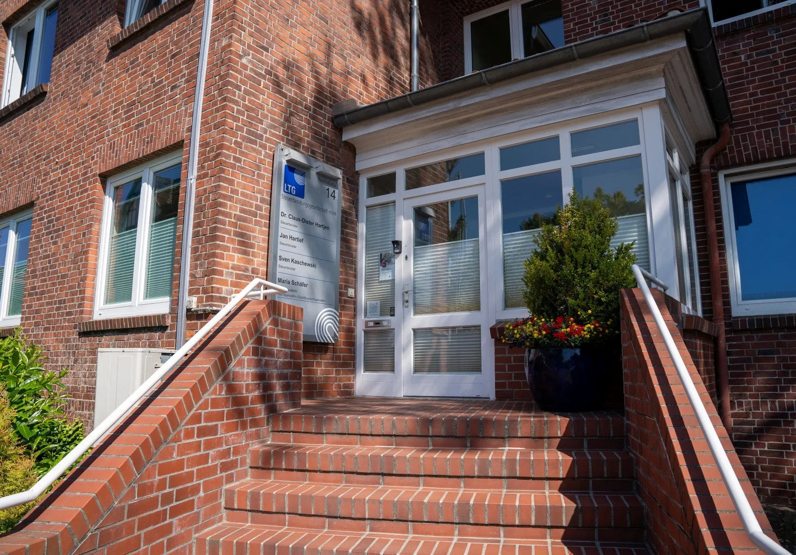 Backsteinhaus mit Treppe und Pflanzen
