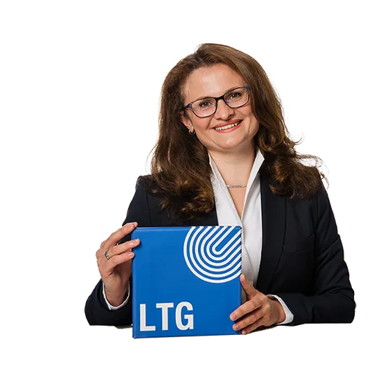 Frau mit LTG-Logo-Mappe lächelt in die Kamera
