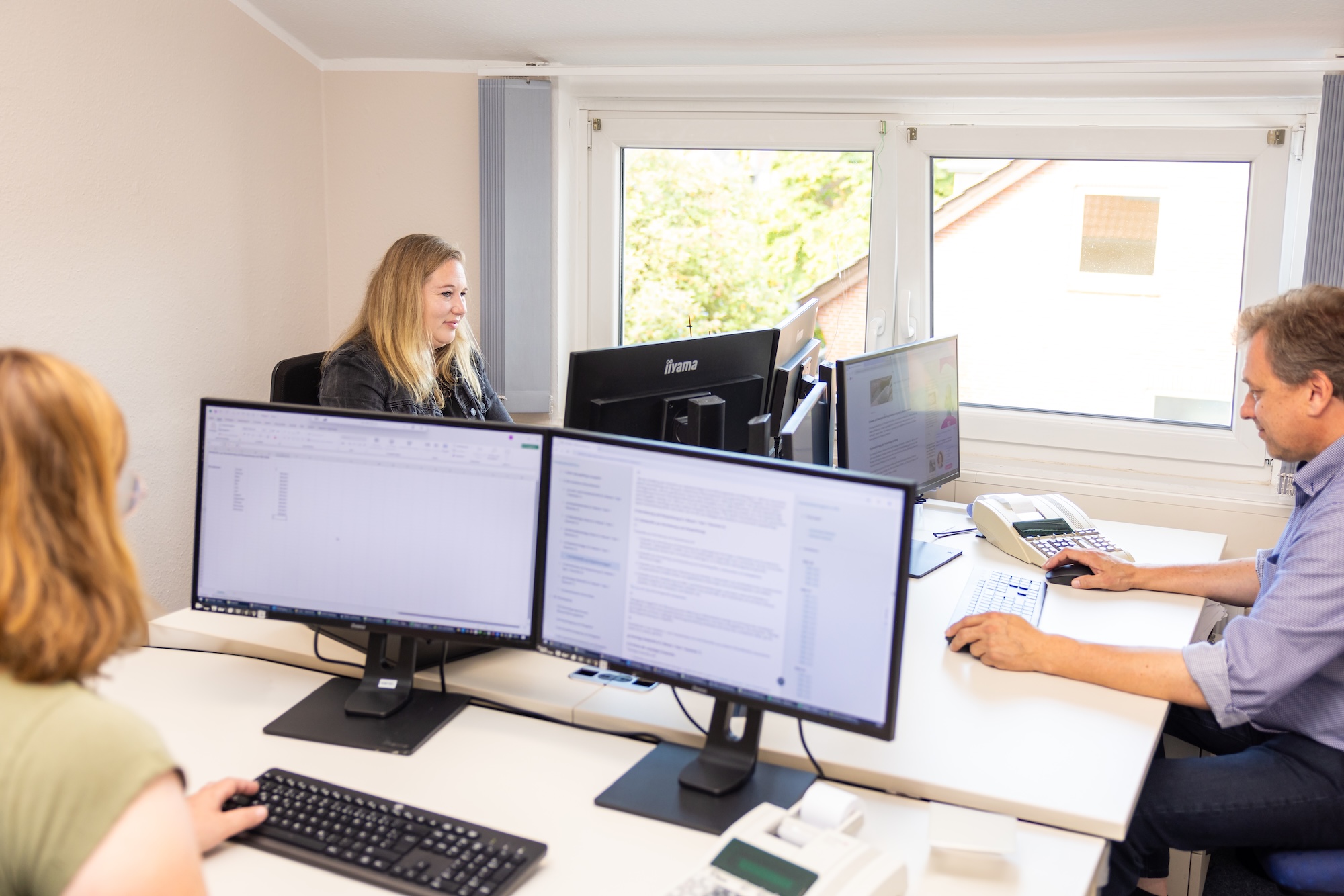 Ein Mann im Anzug steht vor einem Bildschirm mit Statistiken